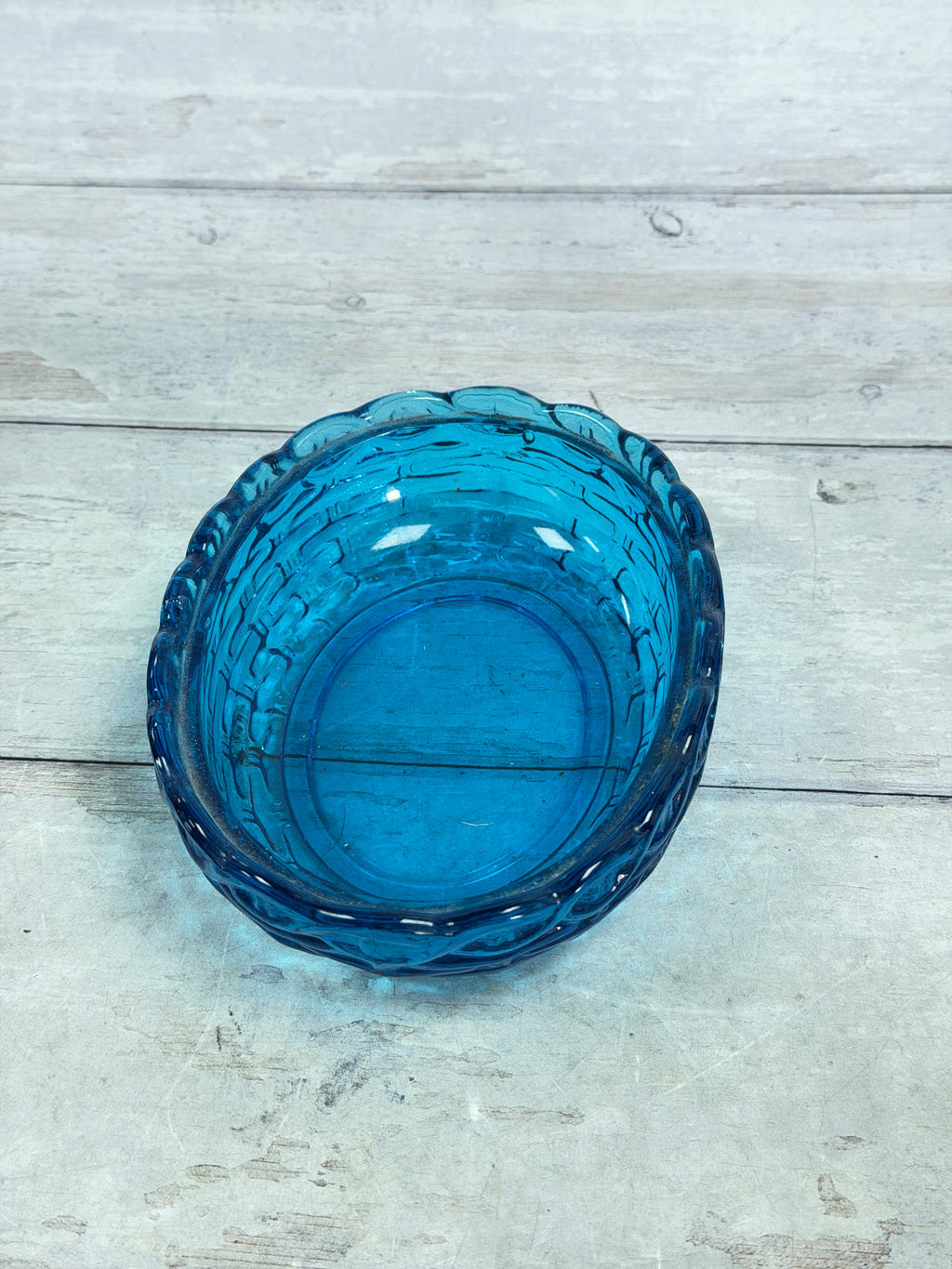 Blue glass covered candy dish base with scalloped rim, top view