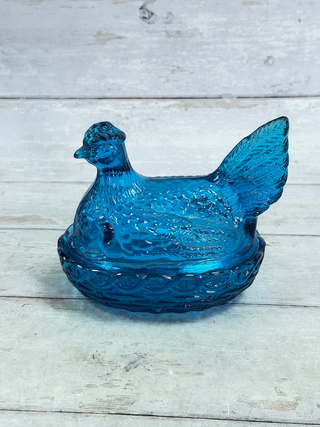 Blue glass hen on nest covered candy dish, profile view