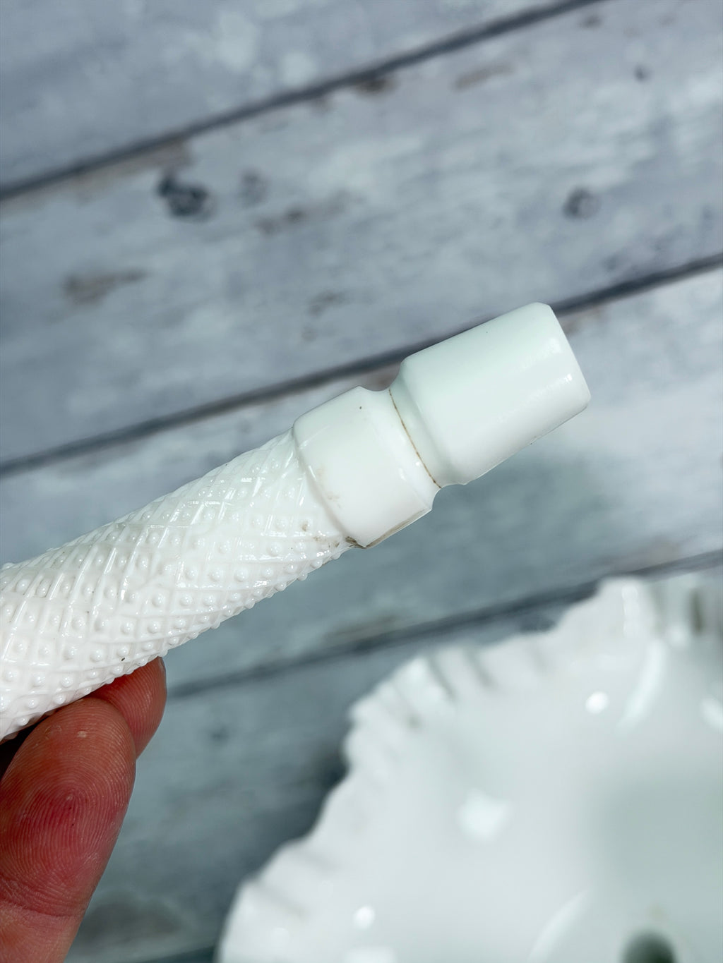 Repaired milk glass epergne horn with visible seam and wrap