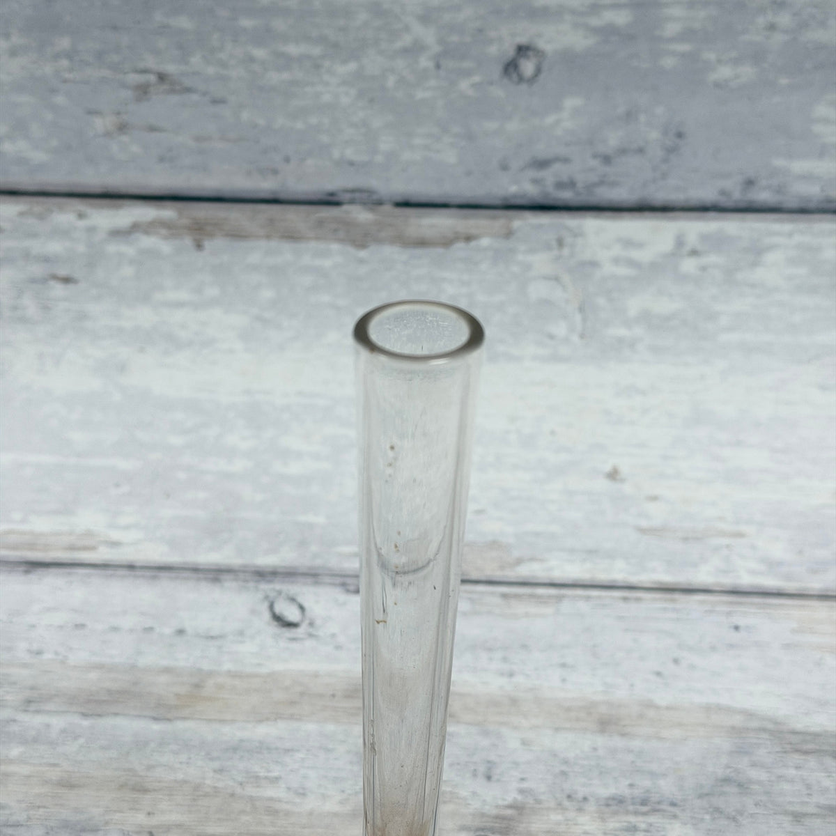 Close-up of circular glass rim and clear neck with visible interior discoloration