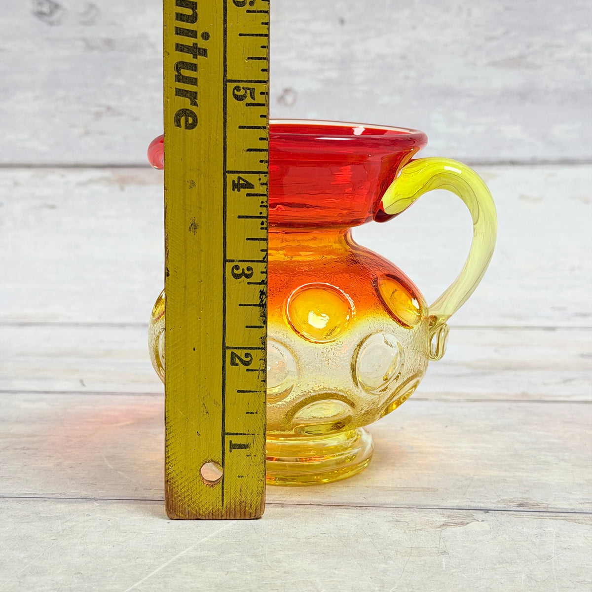 Amberina miniature pitcher beside ruler showing approximately four and a half inches in height
