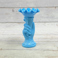 Opaque blue glass hand holding a cornucopia vase with ruffled rim