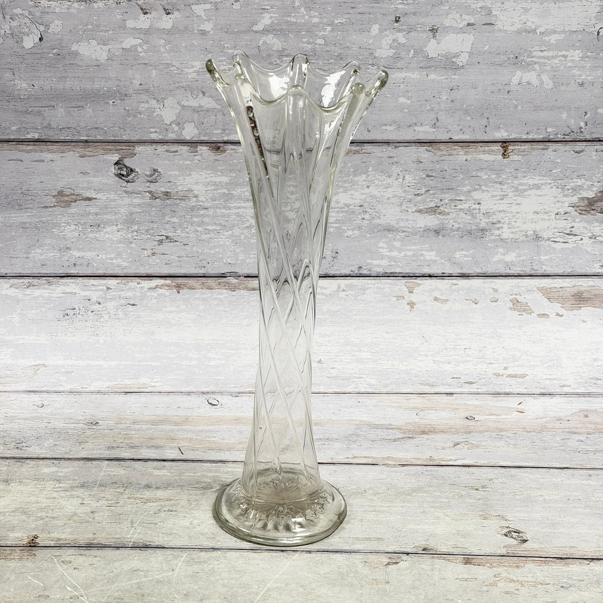 Clear twisted-rib glass vase with eight-point ruffled rim and round foot, front view
