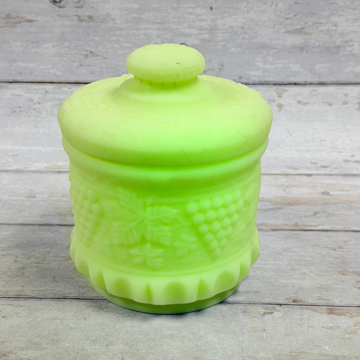 Front view of Fenton custard satin Grape and Cable covered tobacco jar