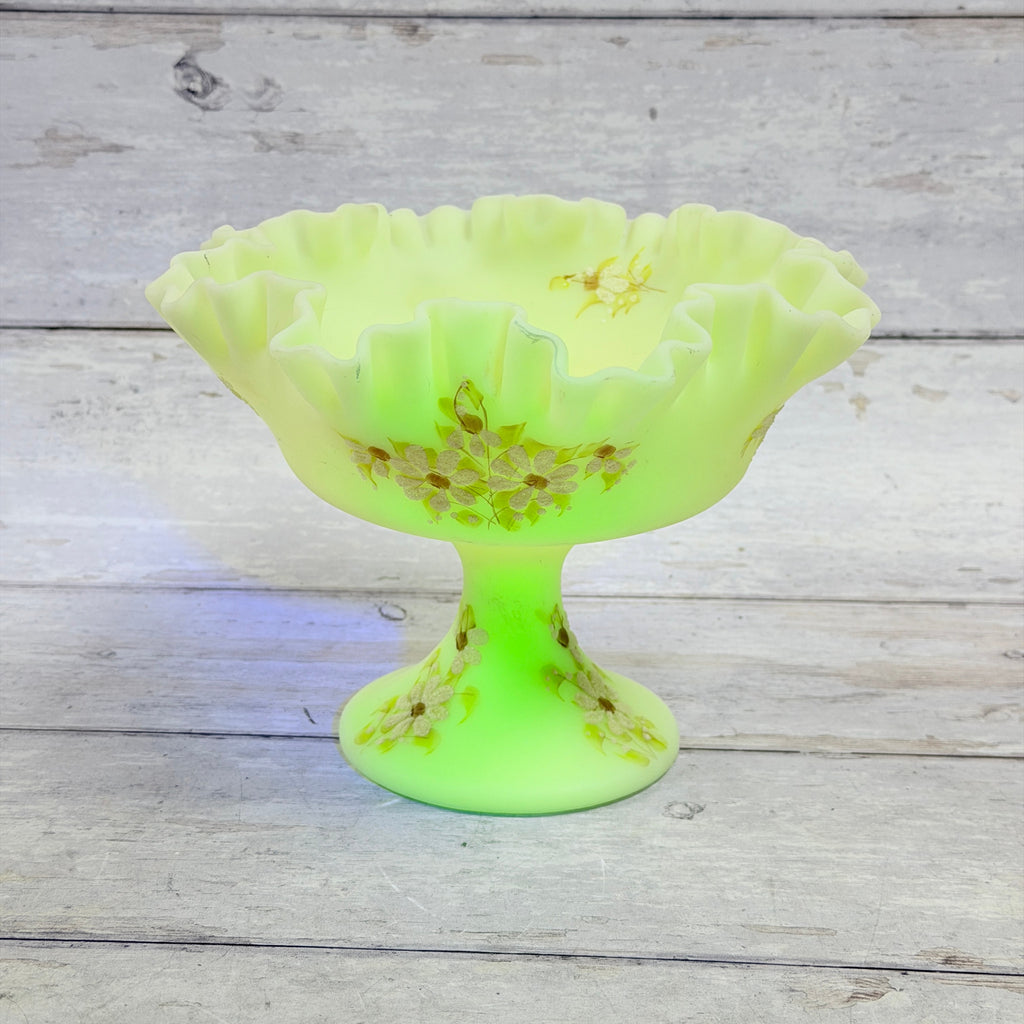 Underside of Fenton custard glass compote showing the molded oval maker mark and painted artist signature
