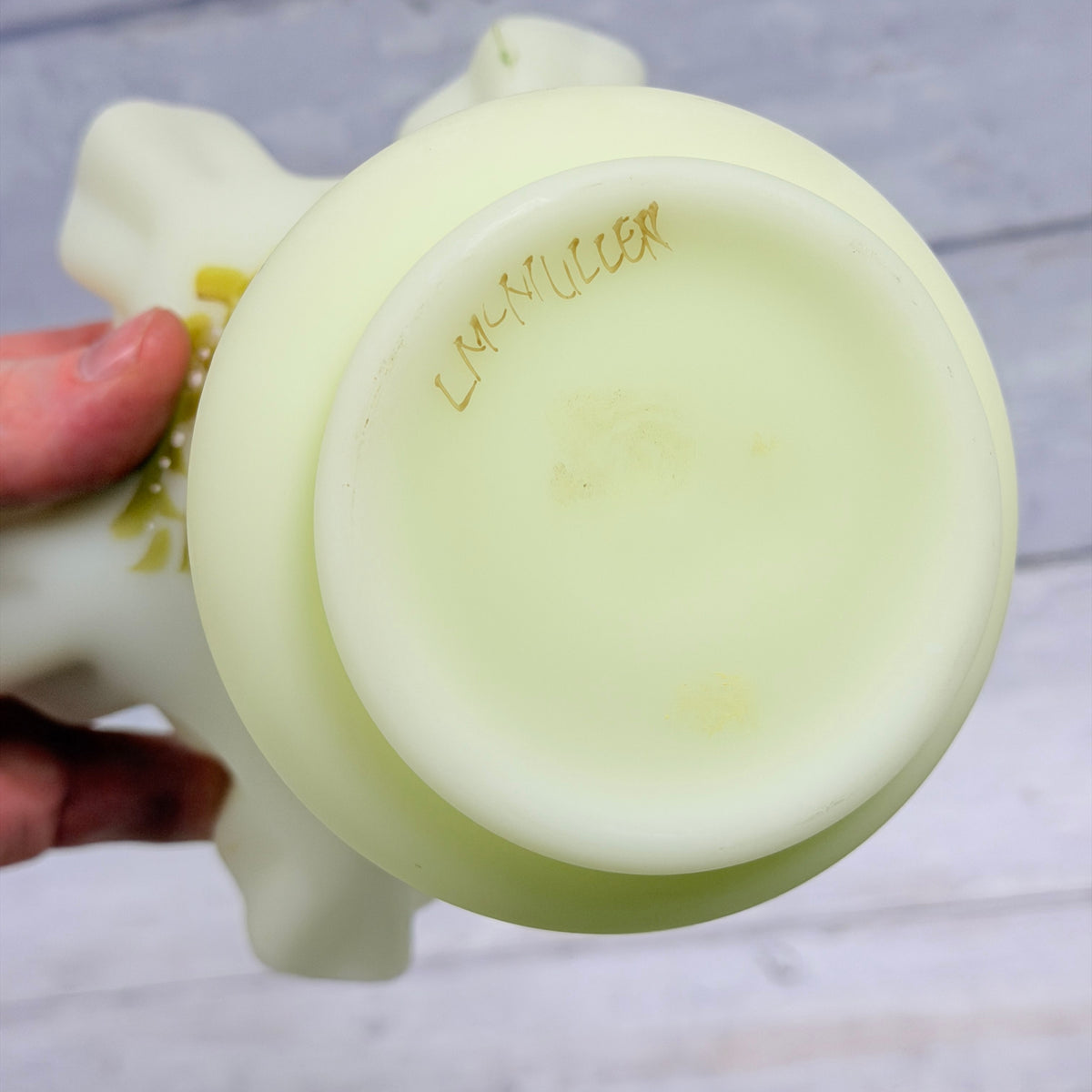 Artist signature and light wear on the underside of Fenton custard glass daisy vase