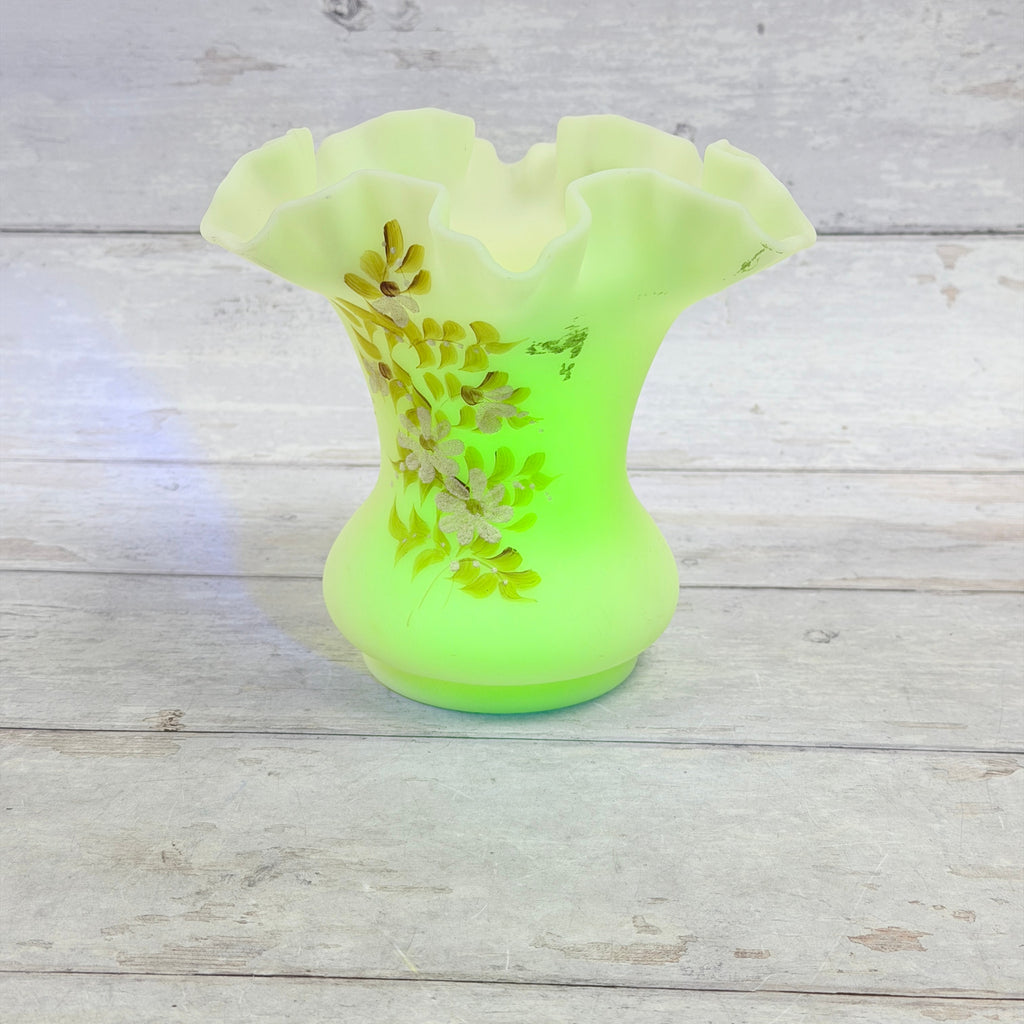 Fenton Daisies on Custard ruffled vase showing bright green fluorescence under UV light