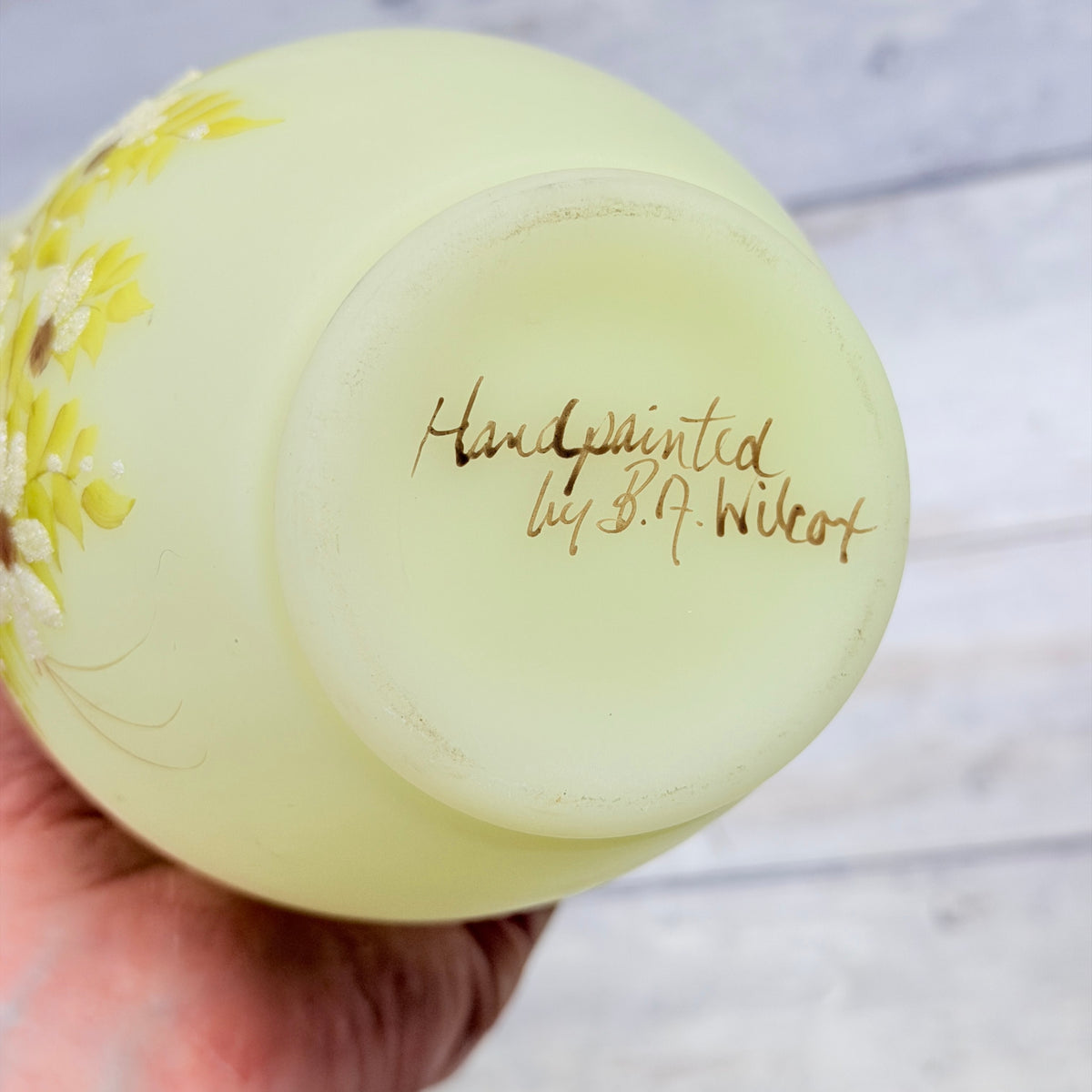Artist signature reading Handpainted by B. A. Wilcox on the underside of the Fenton daisy vase with light base-ring wear