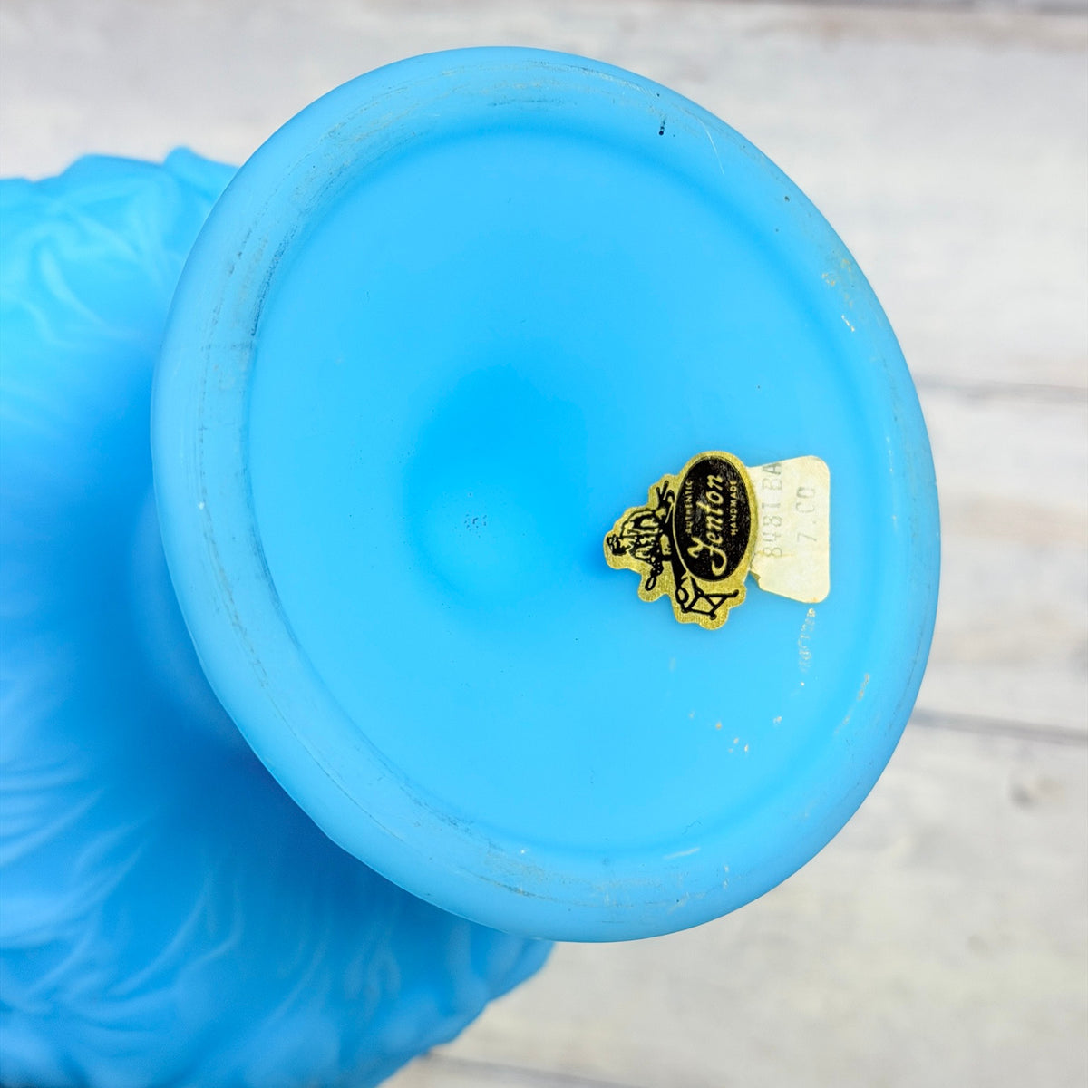 Underside of blue satin compote showing Fenton paper label and foot-ring wear