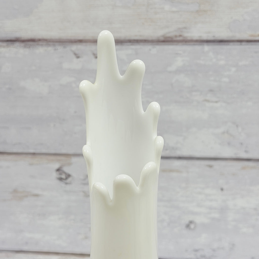 Close-up of elongated finger rim on white milk glass swung vase