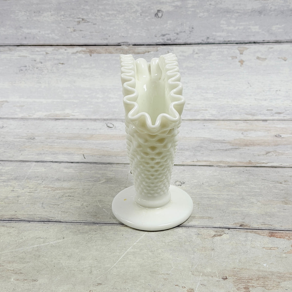 Narrow side profile of white Hobnail fan vase and small tan spot on foot