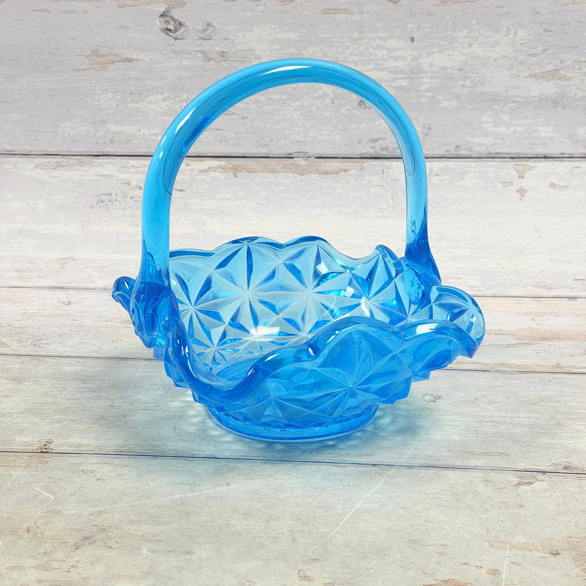 Indiana blue glass basket with geometric star pattern and applied arched handle