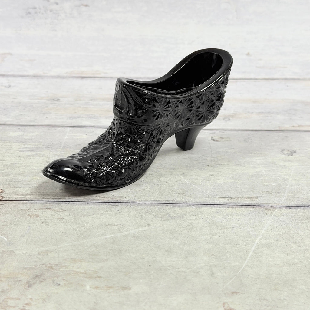 Angled view of black amethyst Daisy and Button glass shoe showing pointed toe and heel