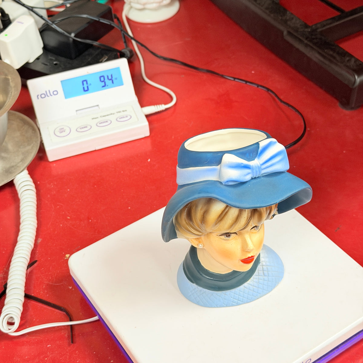 Blue hat head vase on scale