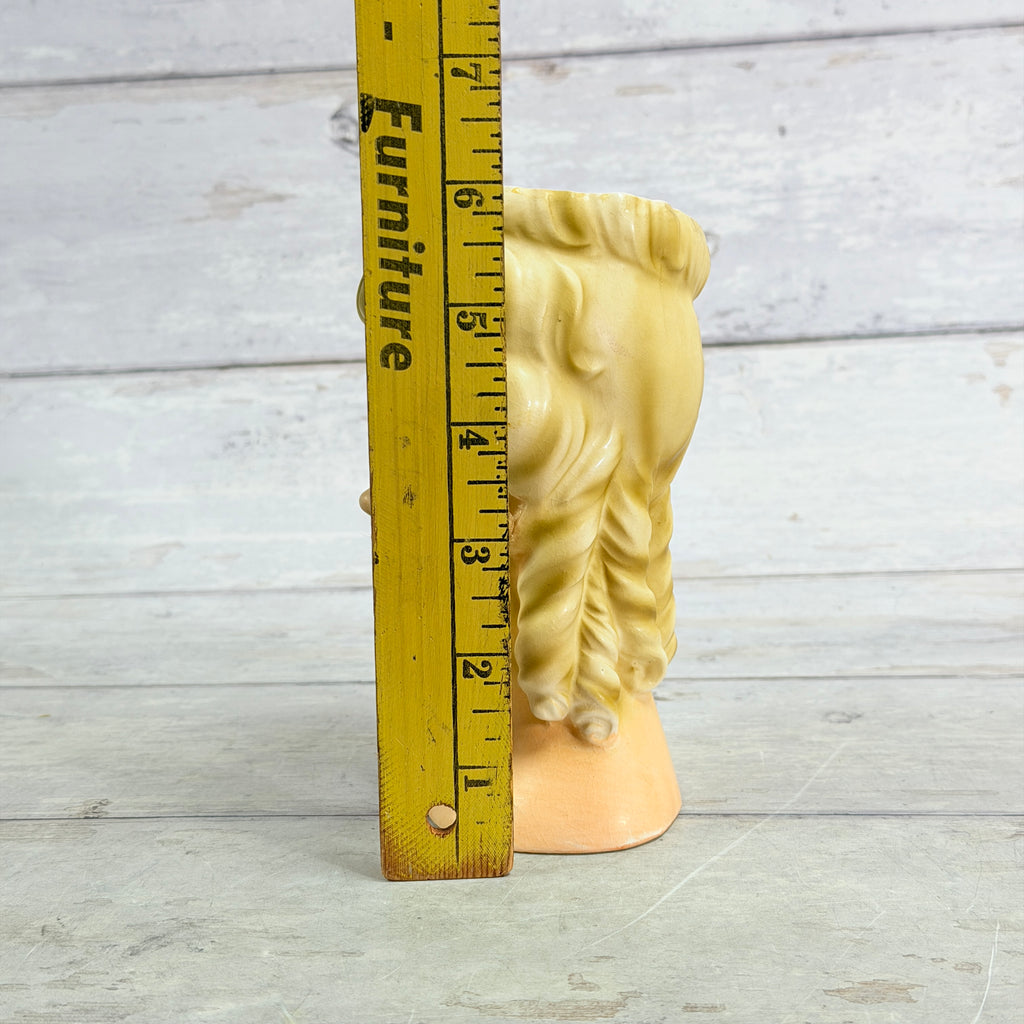 Inarco lady head vase beside height ruler