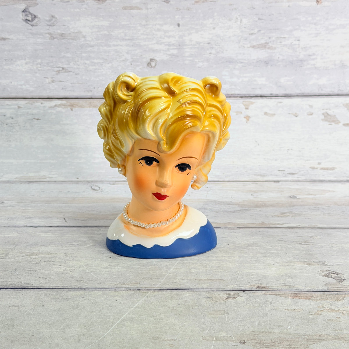 blonde curly-haired head vase with blue dress and white scalloped collar