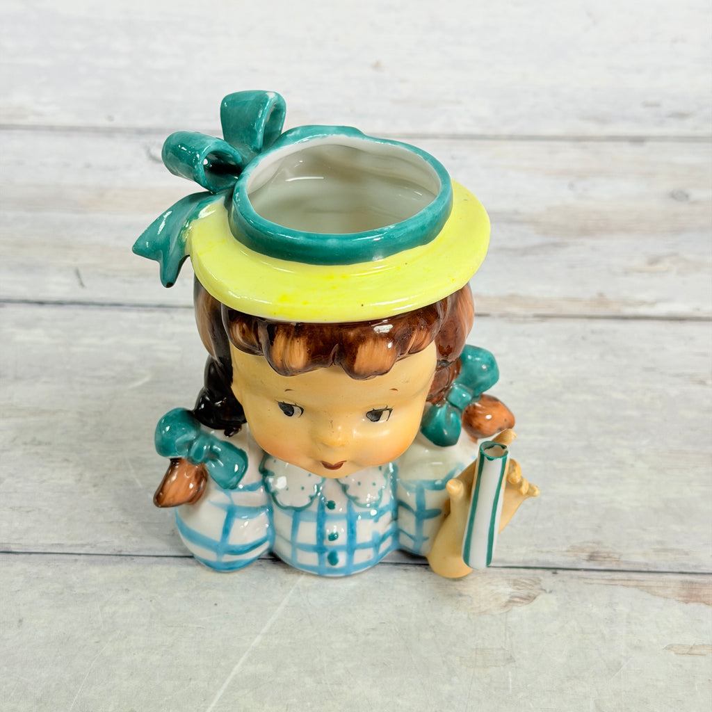 Top view showing teal hat bow and vase opening