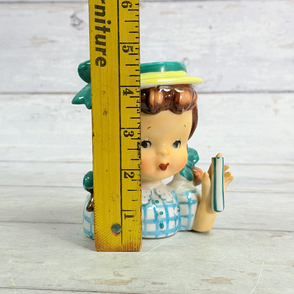 Height ruler beside child vase