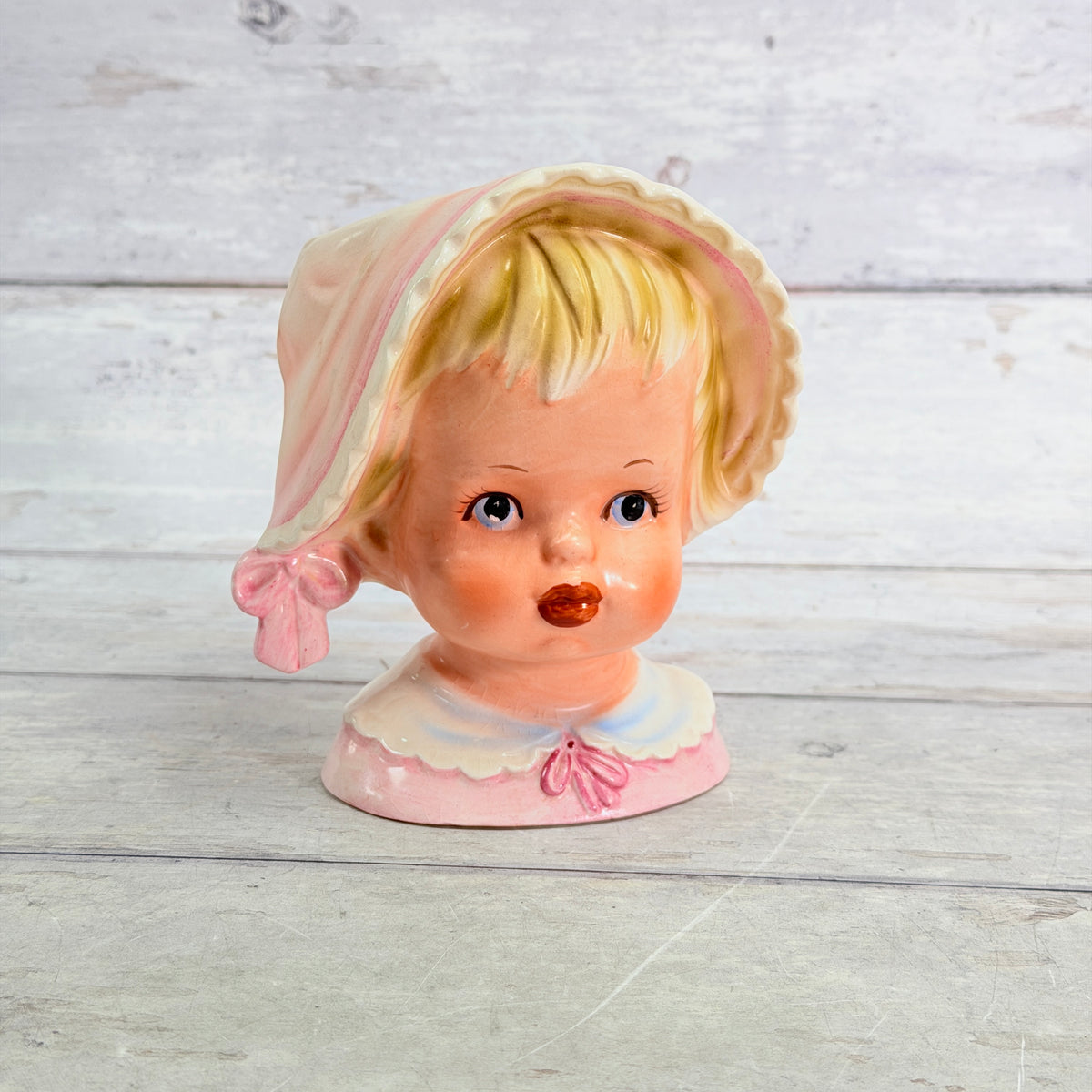 Front of Relpo child vase with blonde bangs and pink bonnet