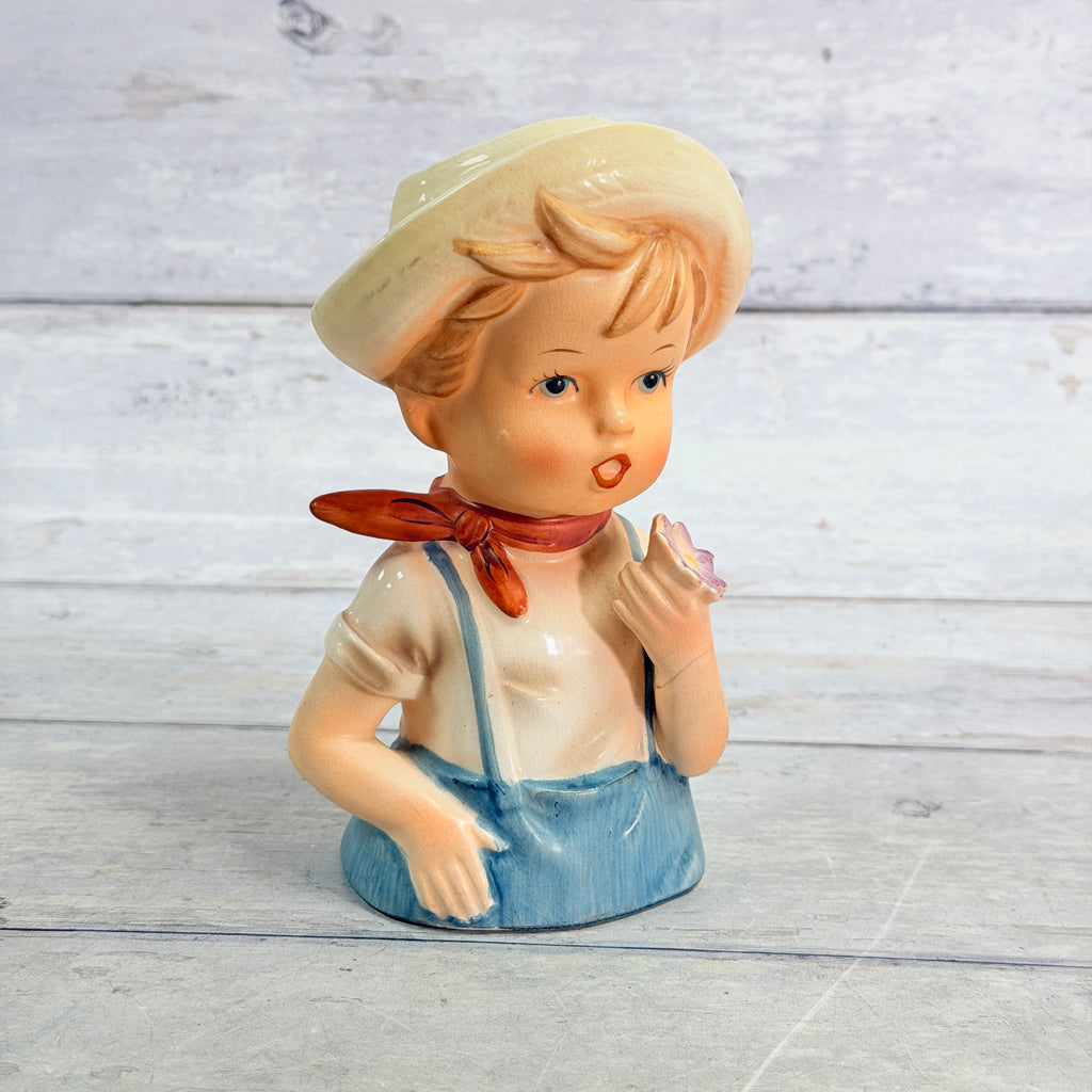 Front of Norleans child vase wearing yellow hat and blue overalls