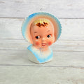 Front of smiling child vase with blue bonnet and bib