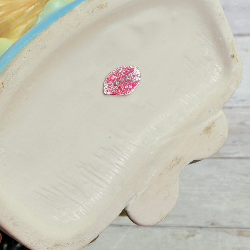 Worn foil label on girl vase base