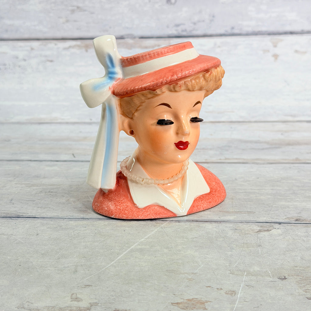Front of Napco coral hat vase with white ribbon