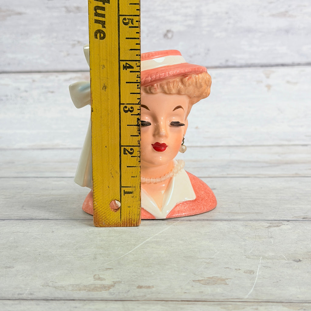 Coral hat vase beside ruler