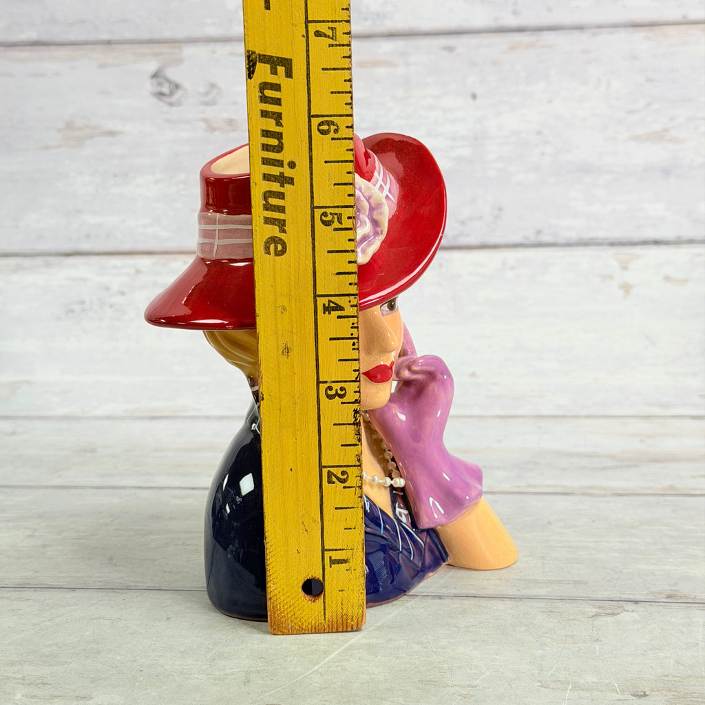 Red hat vase beside ruler