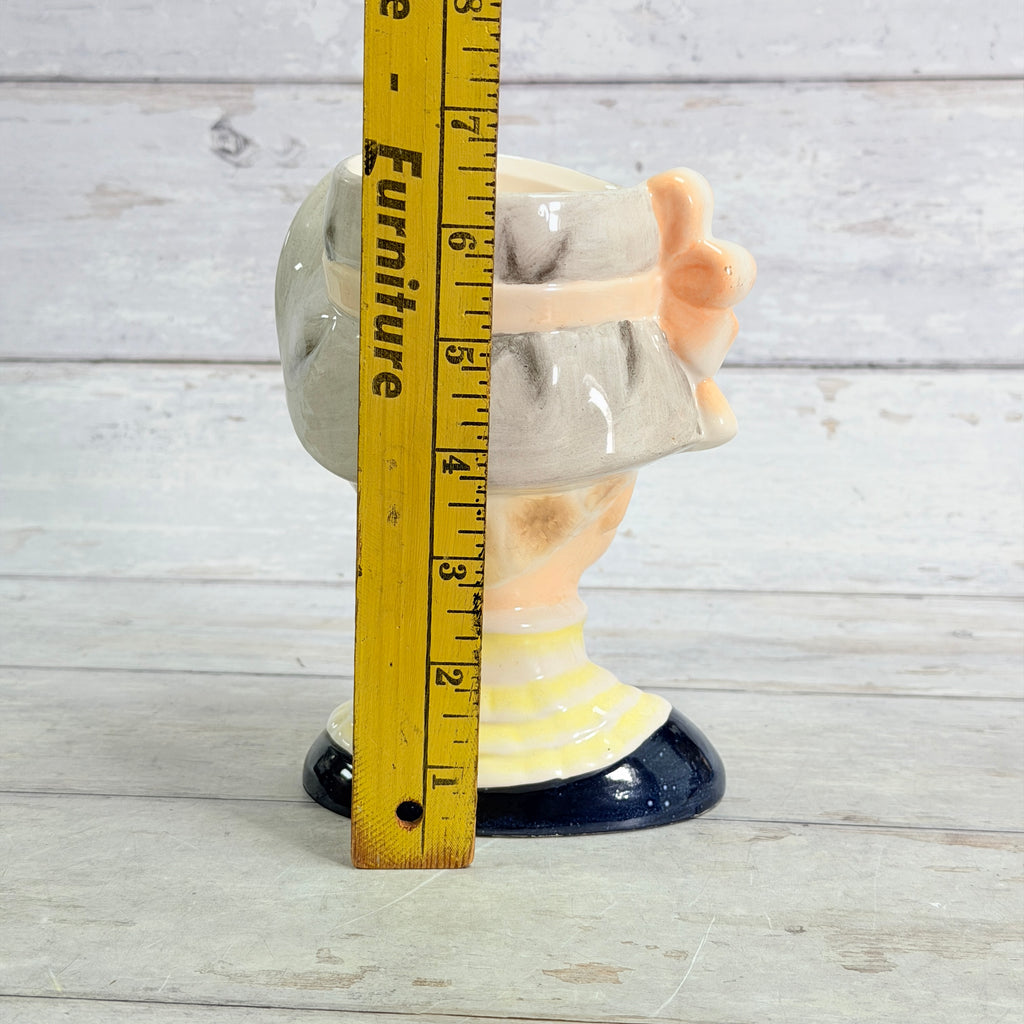Gray hat vase beside ruler
