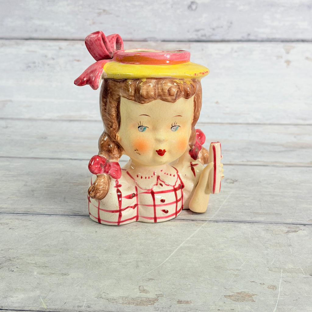 Front of child vase in red checked blouse
