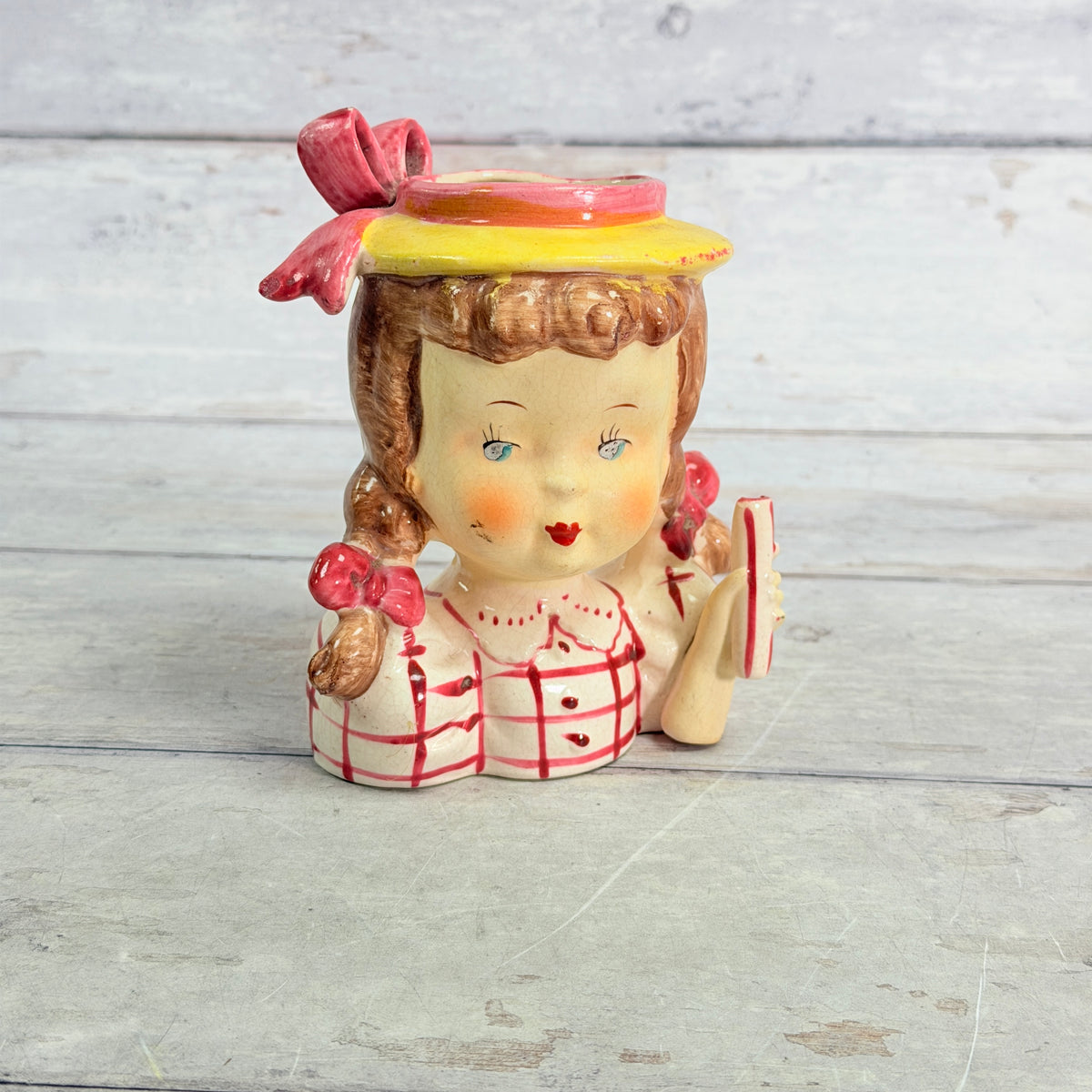 Front of child vase in red checked blouse