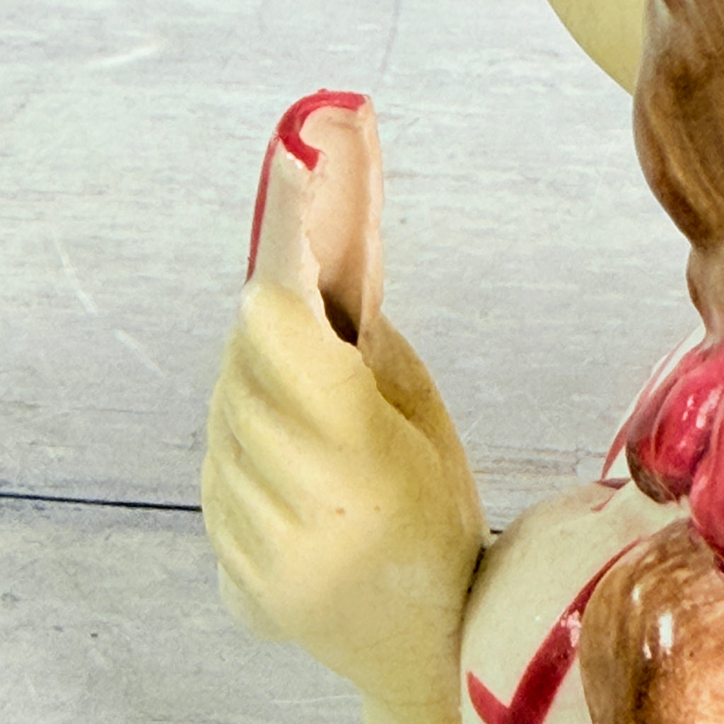 Second close view of chipped cylinder beside hand