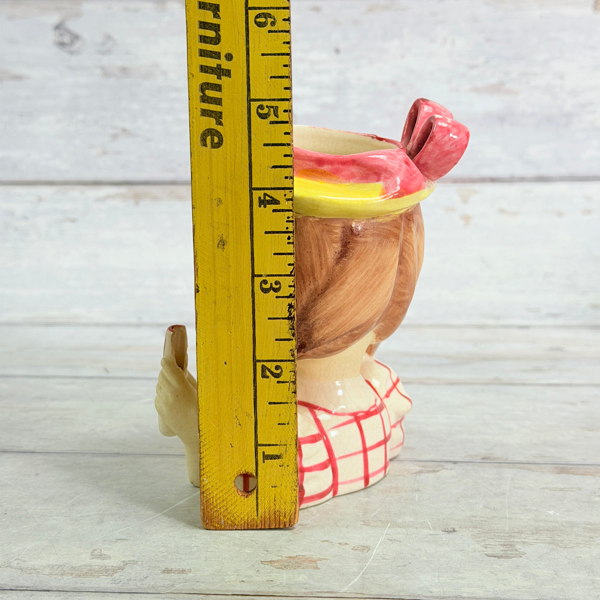 Red plaid child vase beside ruler