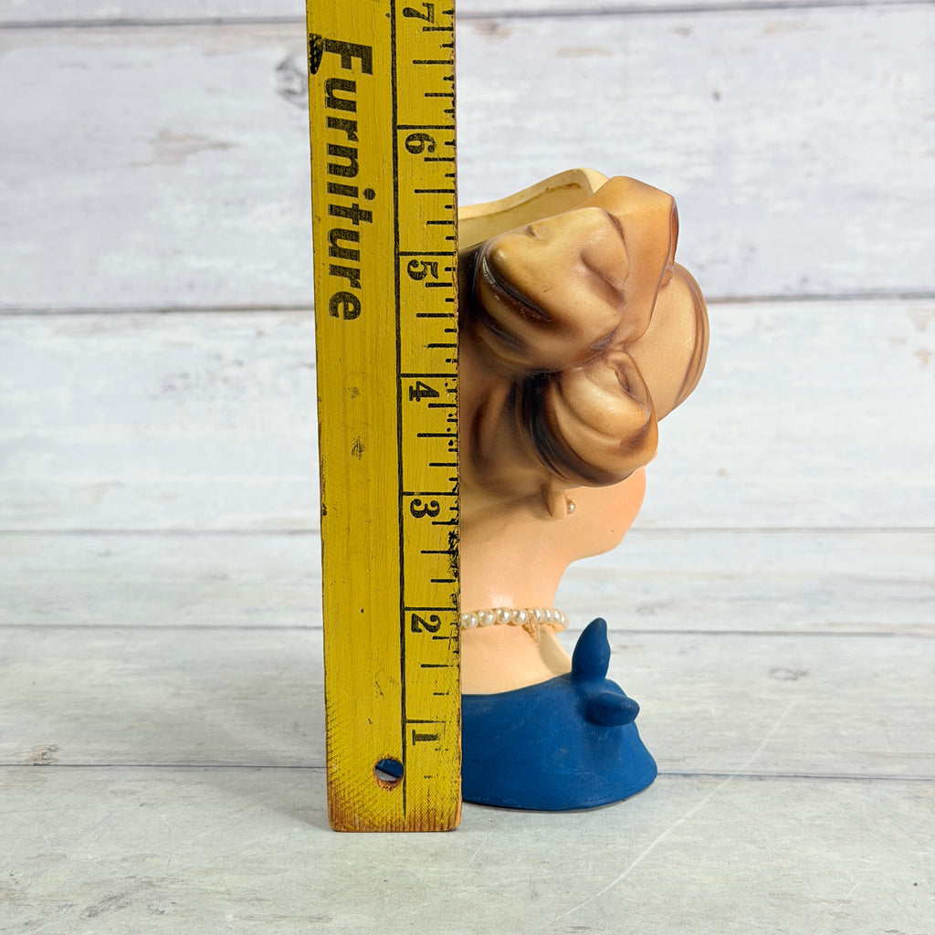 Brown updo vase beside ruler