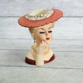 LH33 — Front of coral hat vase with hand at cheek