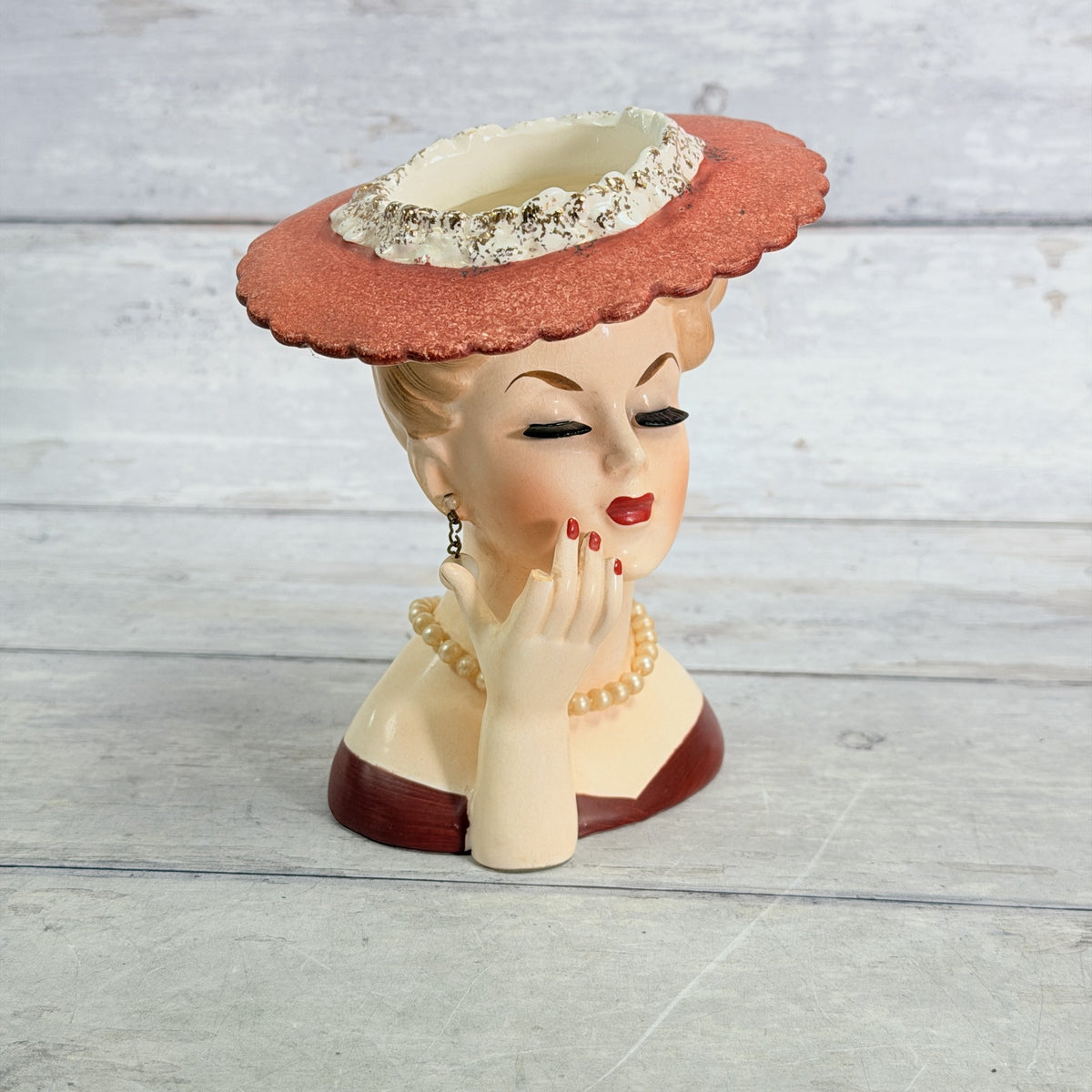 LH33 — Front of coral hat vase with hand at cheek