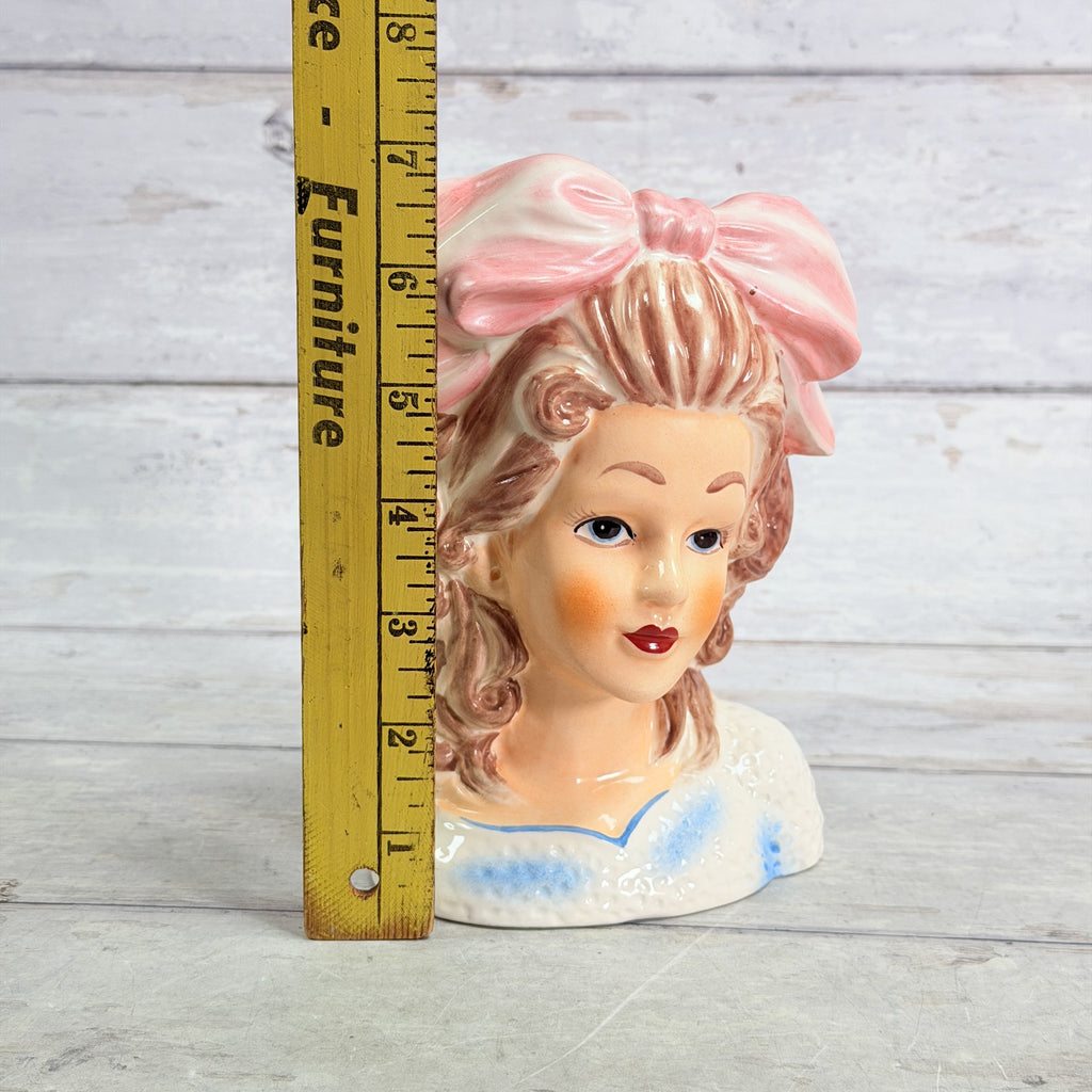 LH44 — Pink bow vase beside ruler