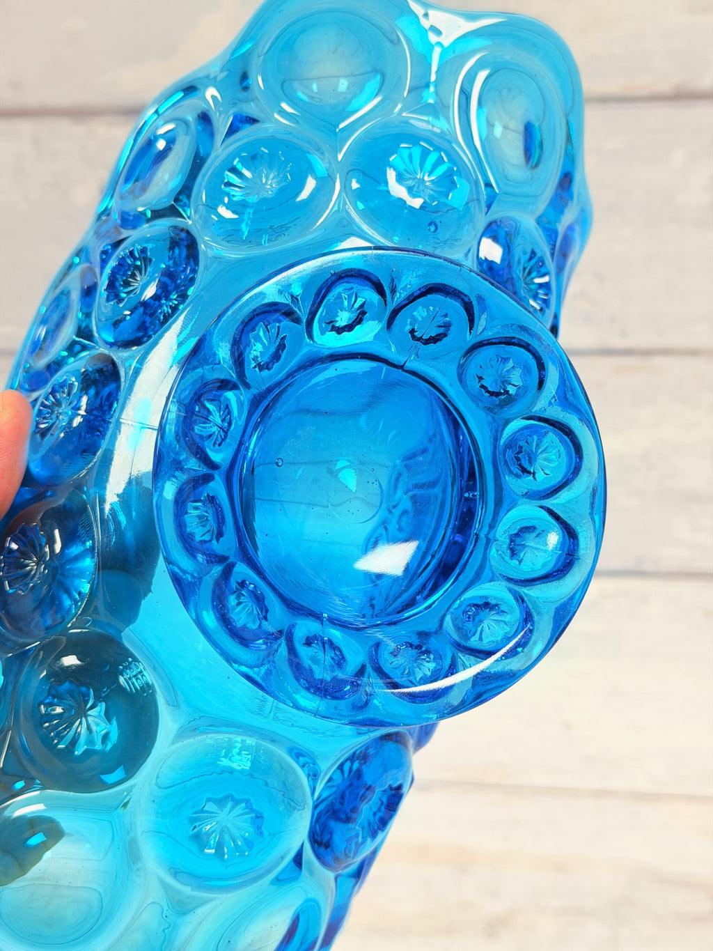 Underside of colonial blue Moon and Star banana bowl showing pressed glass star pattern on pedestal
