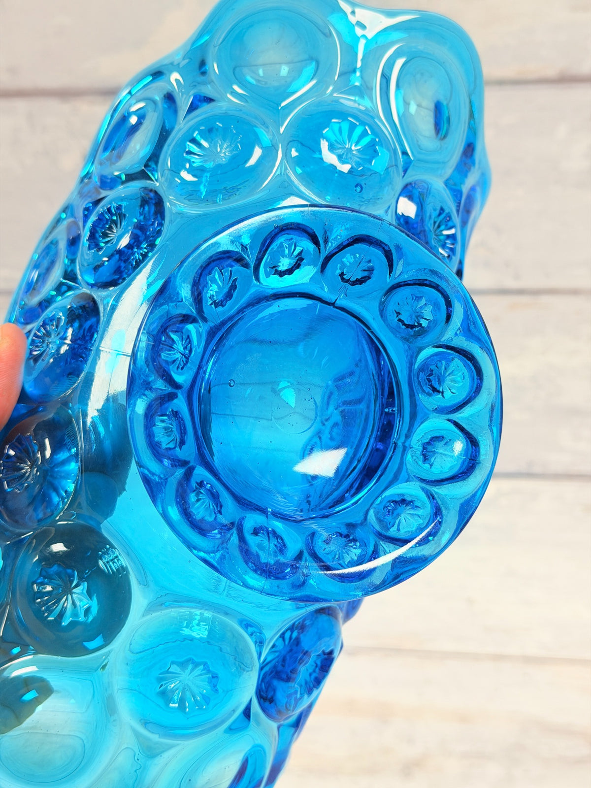 Underside of colonial blue Moon and Star banana bowl showing pressed glass star pattern on pedestal
