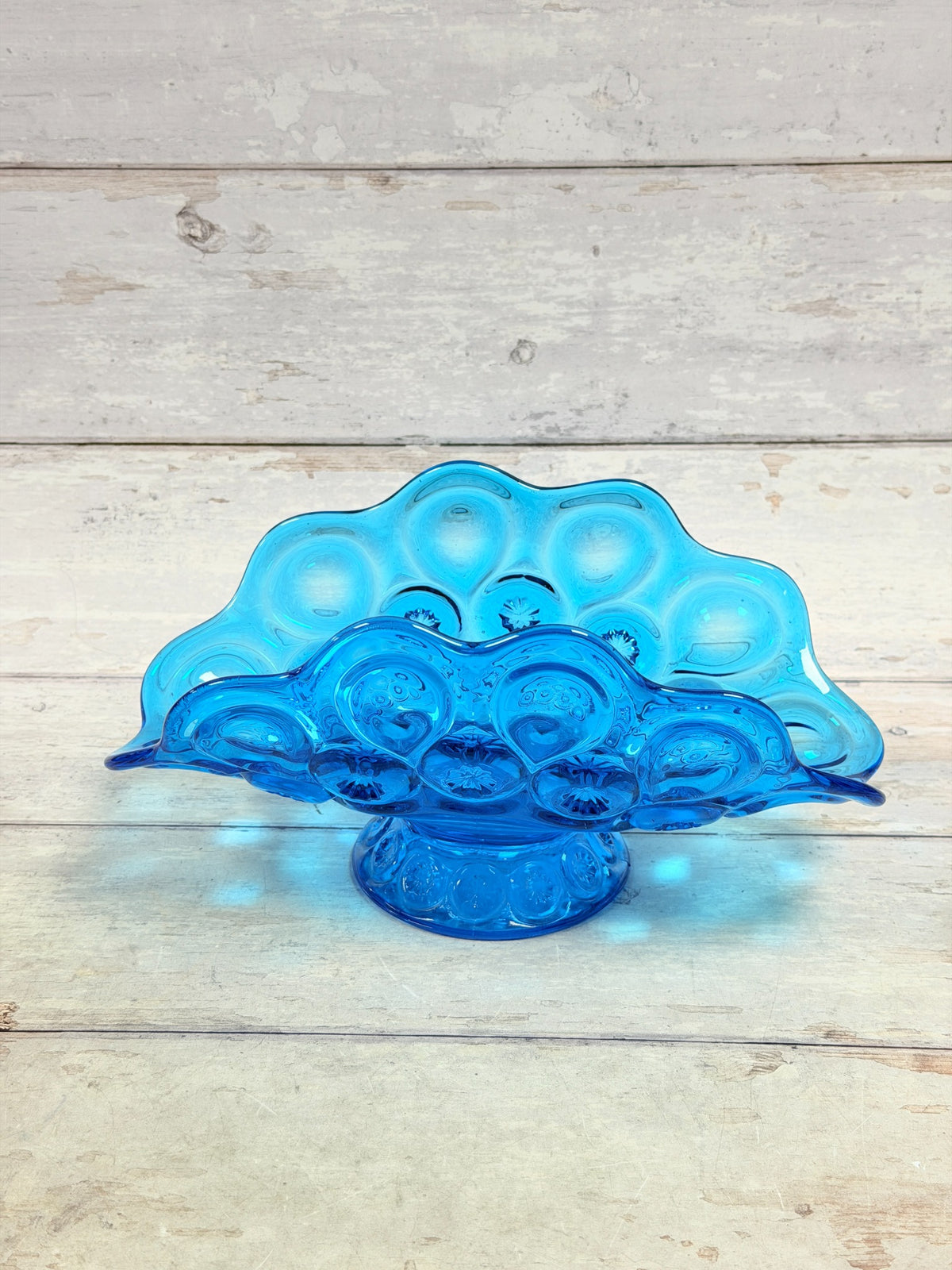 Side view of colonial blue Moon and Star pedestal banana bowl showing scalloped rim