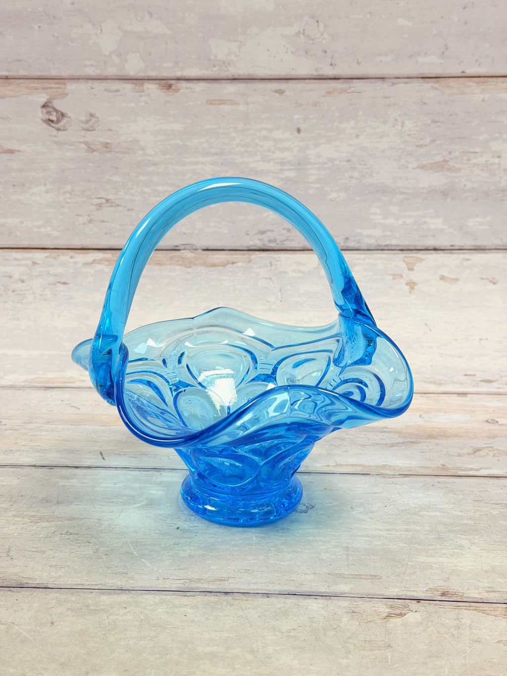 Front view of Colonial Blue Moon and Star footed glass basket with arched handle