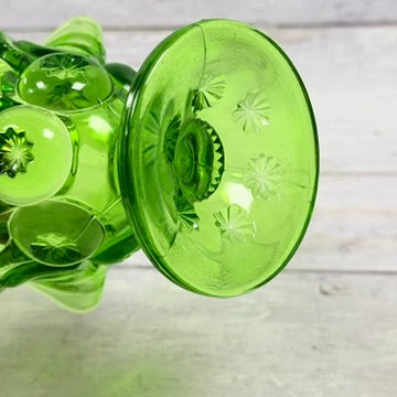 Underside starburst pattern of green glass compote