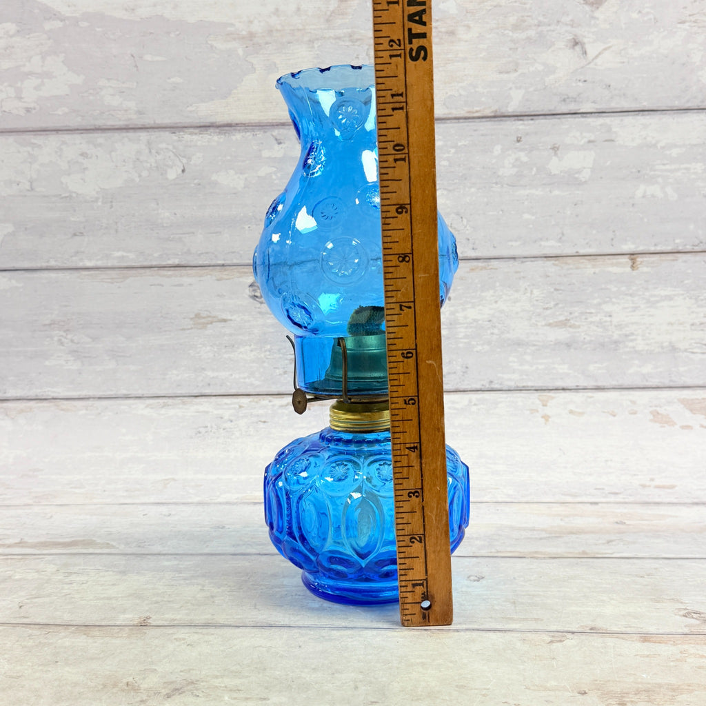 Oil lamp beside ruler approximately twelve inches tall