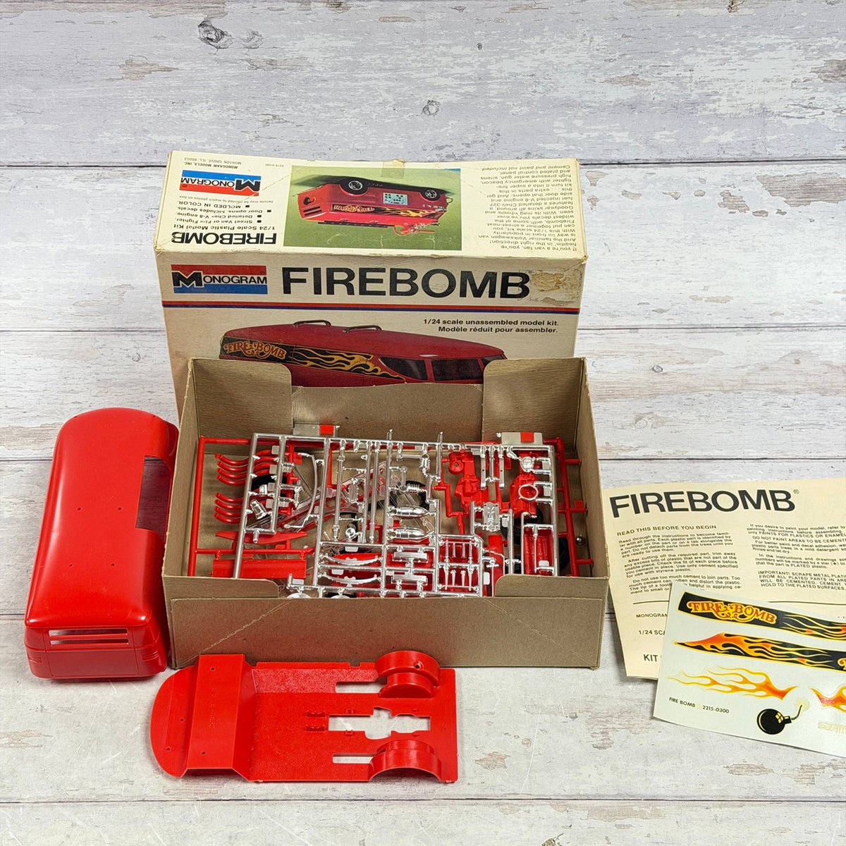 Open Monogram Firebomb kit with red parts, chrome sprues, instructions and decals