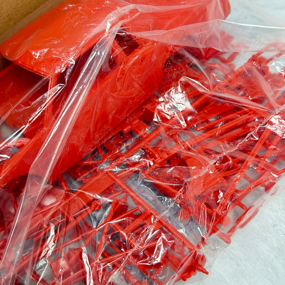Red model kit parts inside clear bag