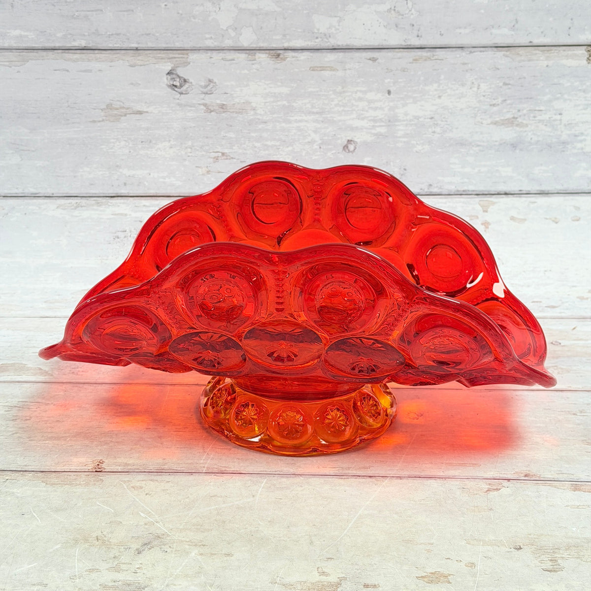 Front view of the amberina banana bowl with scalloped rim and amber pedestal foot