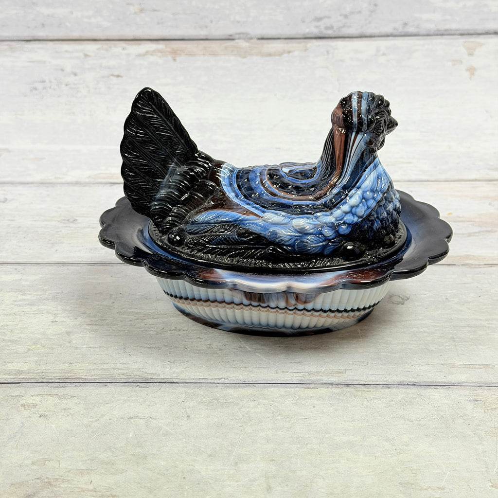 Front view of Mosser Glass amethyst and white slag hen-on-nest covered dish