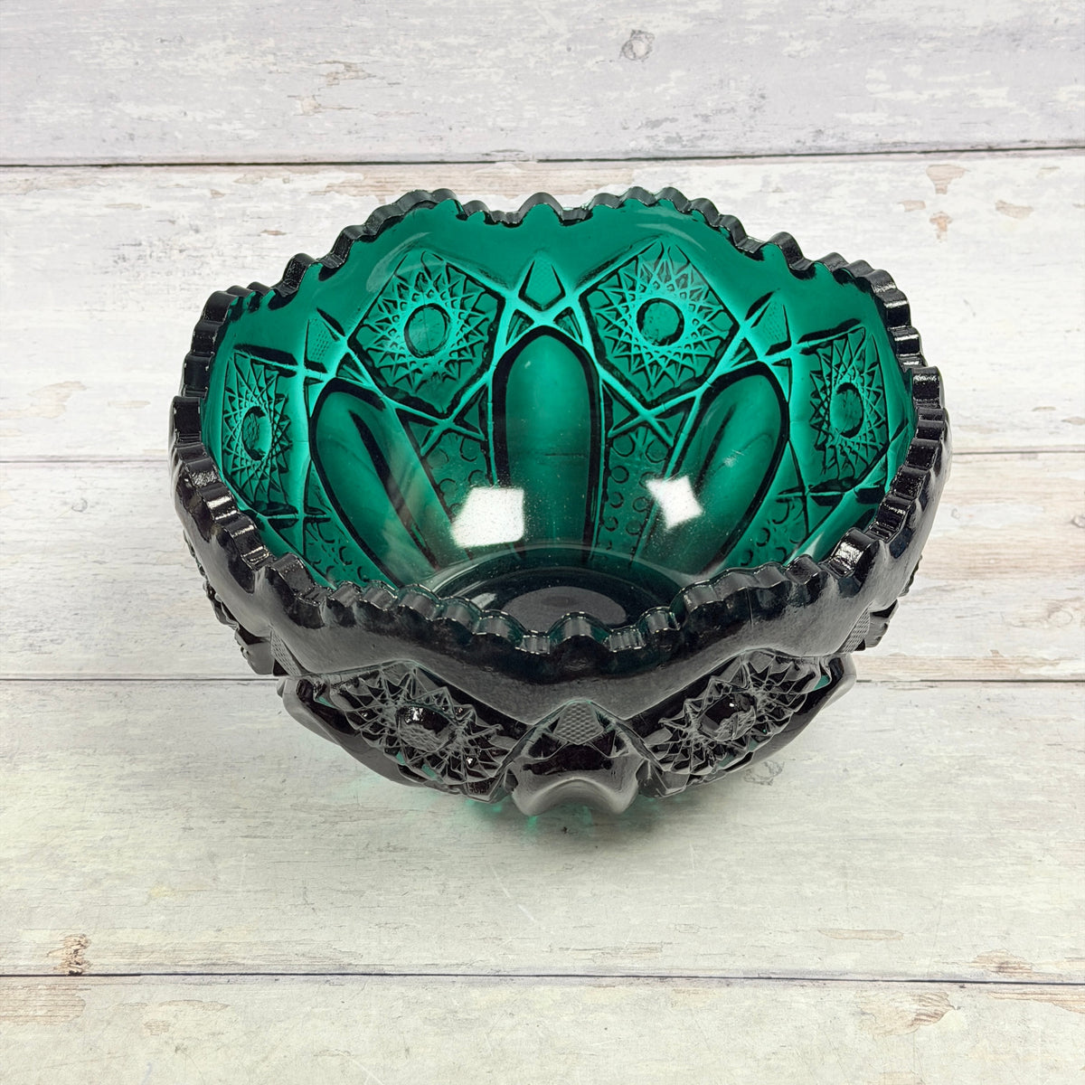 Angled top view of Greenbriar teal glass bowl showing the interior, scalloped rim and geometric pressed-glass pattern