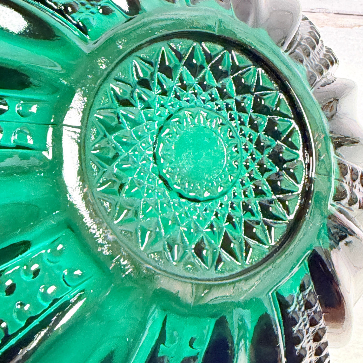Underside detail of L.E. Smith Greenbriar teal glass bowl showing the molded starburst and base ring